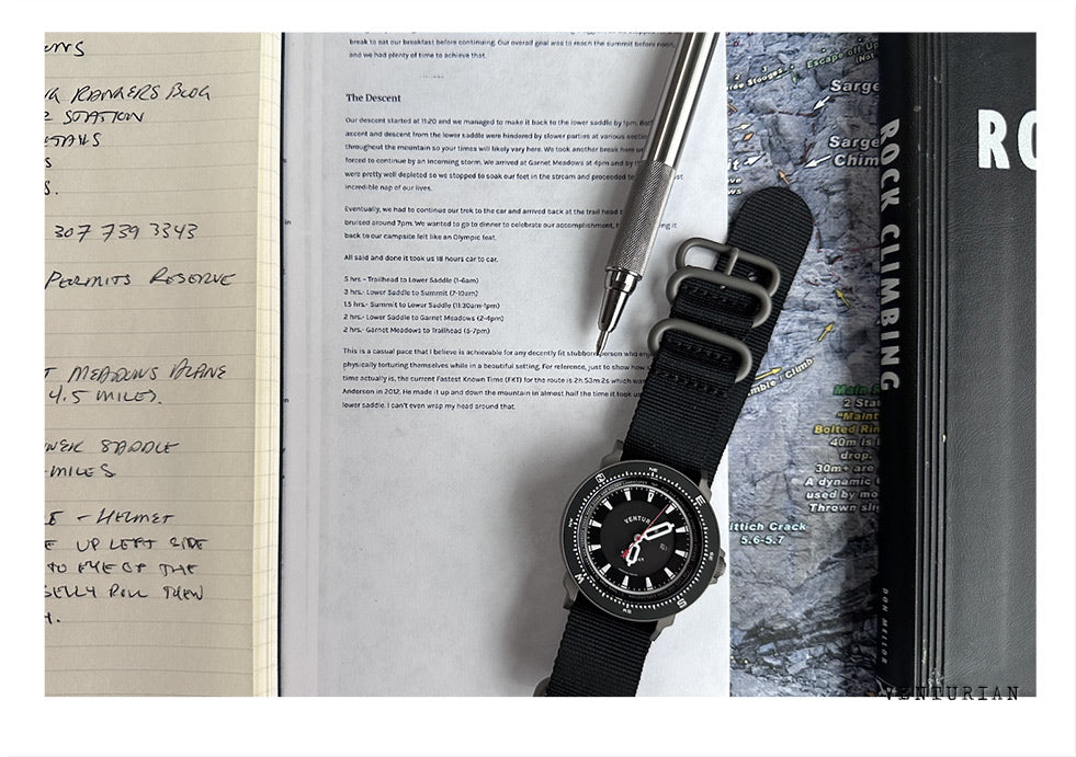 photo of a hand written journal with a watch and pen