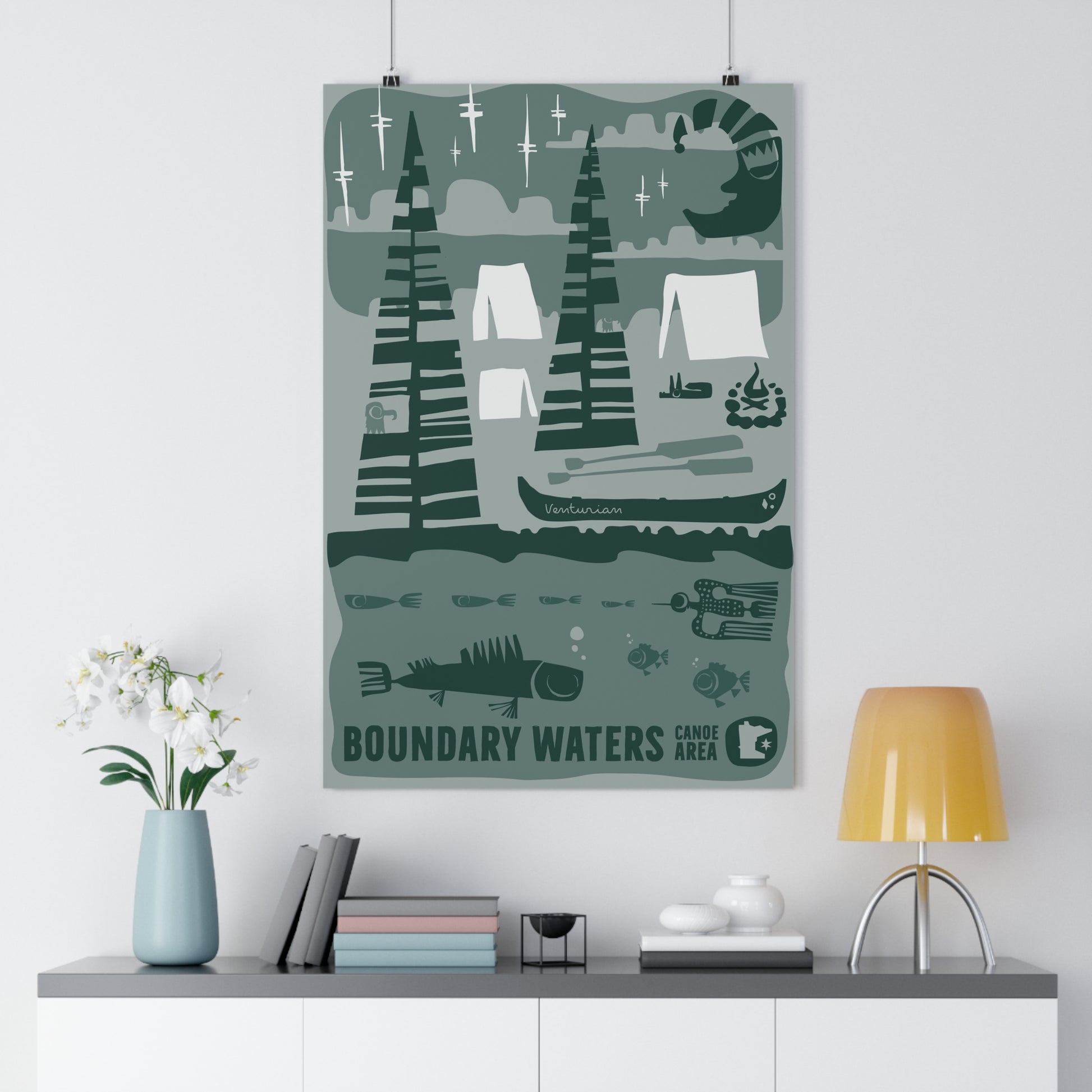 Poster of the Boundary Waters Camp Area on a wall above a shelf with decor items.