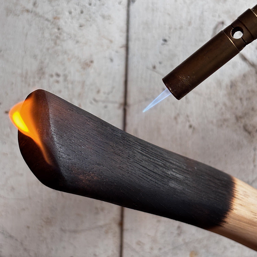 unique gift idea for dad is this Butane lighter igniting a wooden stick with flame on a concrete surface