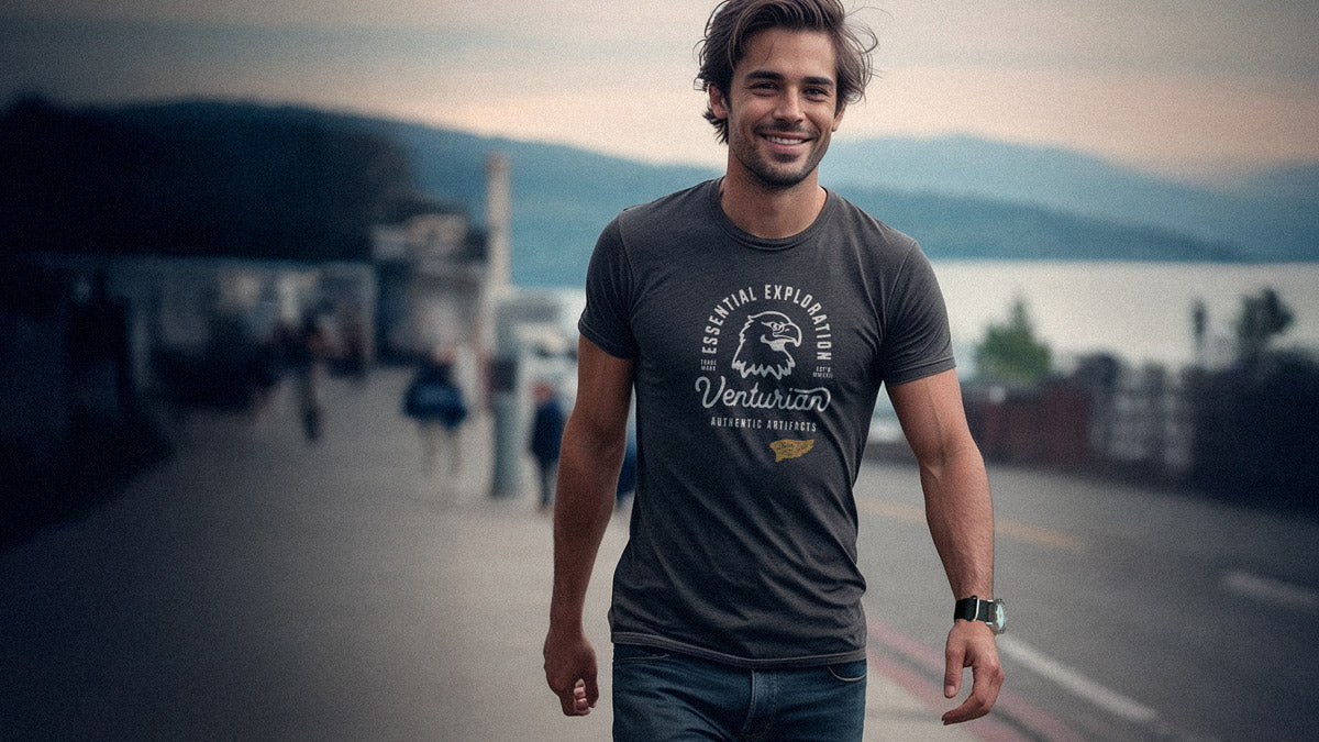 Man wearing a t-shirt with a logo and text, standing on a street with a blurred background