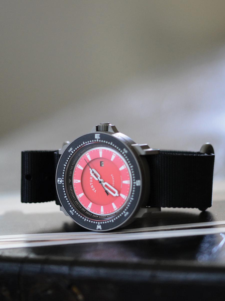 The Venturian Wildsider 38MM Solar Titanium compass tool watch in Red on table