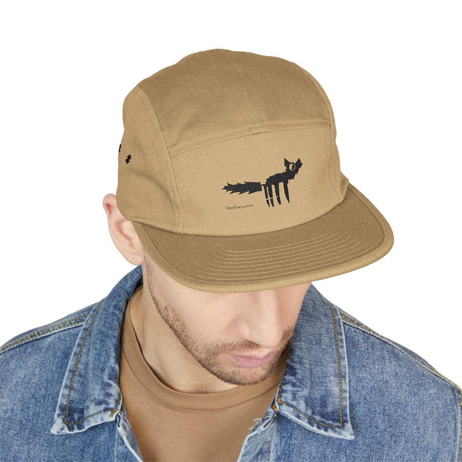 Tan cap with fox design worn by a person on a white background