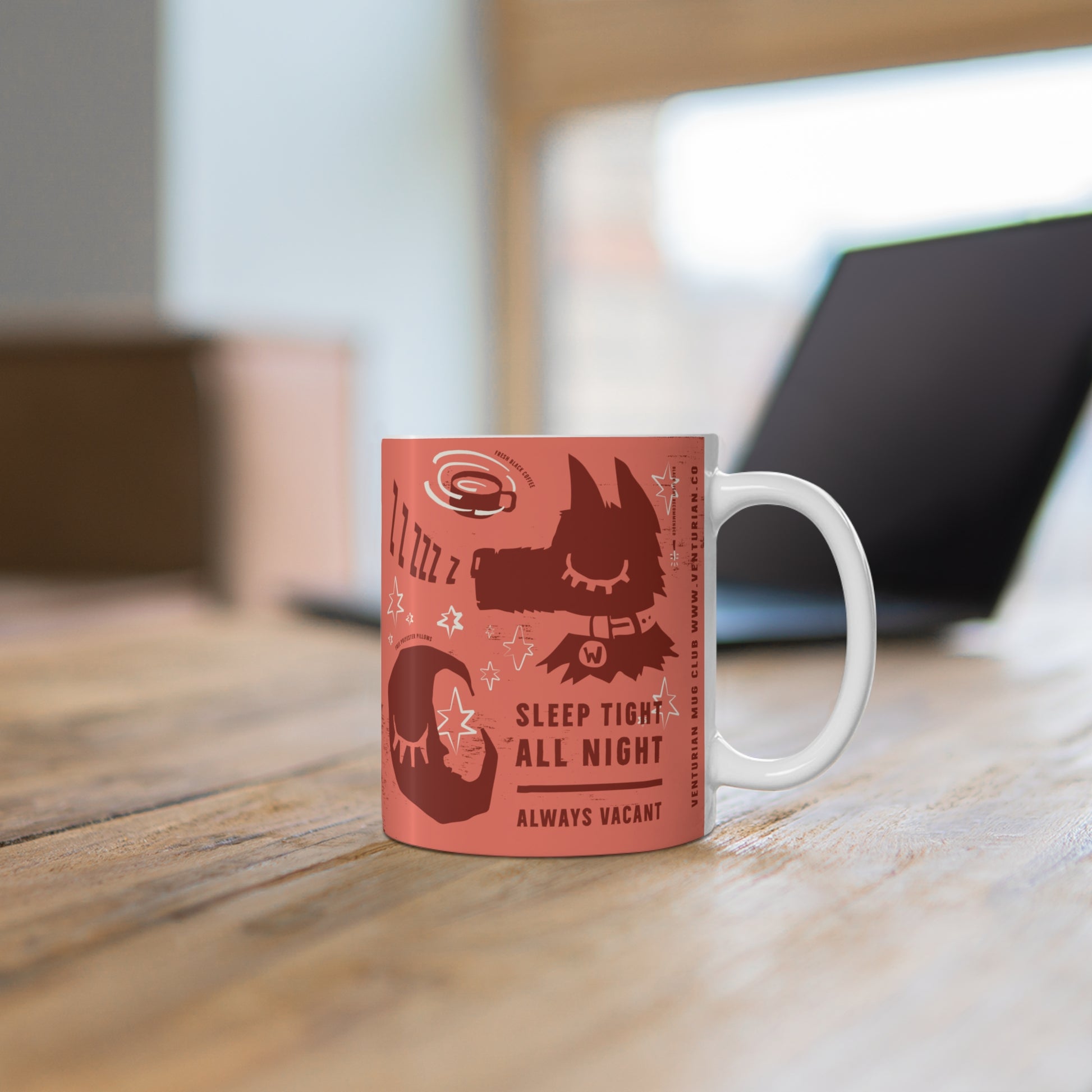 Red mug with black cat design and text on a wooden surface